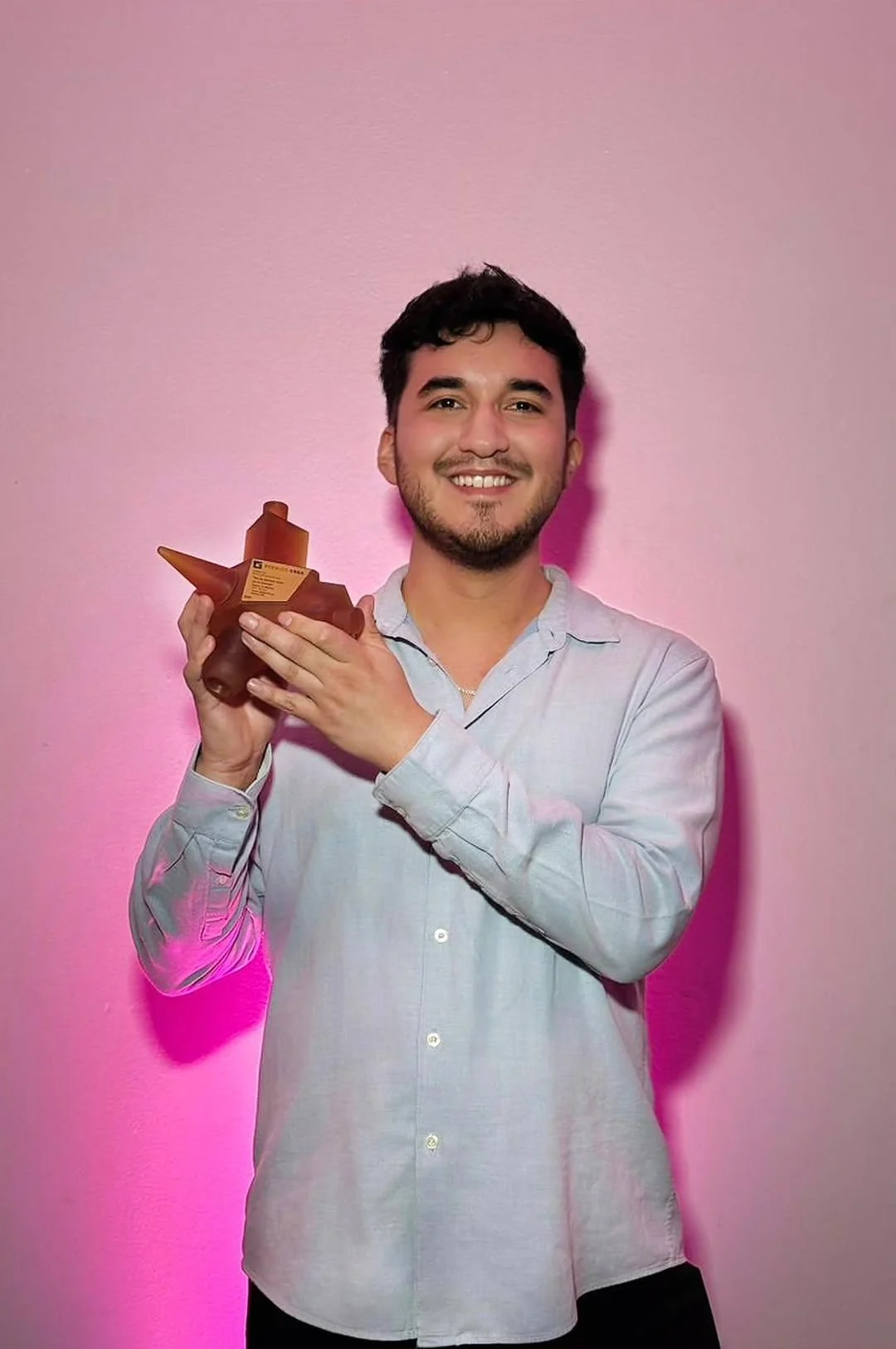 Lucas holding a CREA award at the ceremony with the SKY team